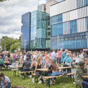 Menschengruppen sitzen Draußen vor der Rhein-Mosel-Halle © Koblenz-Touristik GmbH